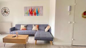 een woonkamer met een blauwe bank en een tafel bij Le Cocon Urbain - WiFi - Balcon - Parking privé in Courcouronnes