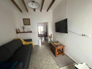 uma sala de estar com um sofá preto e uma televisão em CASA EL MIRADOR FIGUEROLES em Figueroles