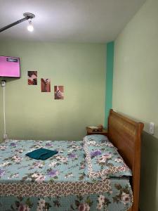 a bed with a quilt on it in a bedroom at Hospedagem Zefino in Cunha +11 photos