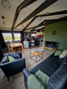 a living room with a couch and a table at Green Farm Stay with private hot tub in Hvolsvöllur