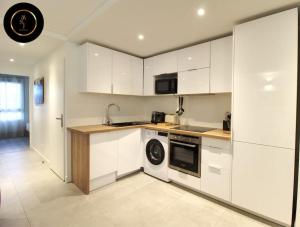 a kitchen with white cabinets and a dishwasher at Appartement à 4 kms de Disney in Magny-le-Hongre