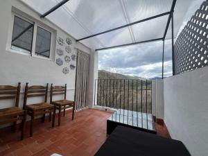 um quarto com bancos e uma varanda com vista em CASA EL MIRADOR FIGUEROLES em Figueroles