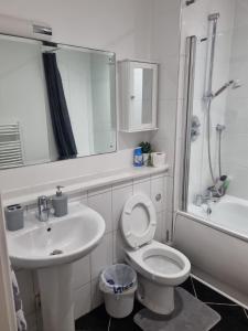 Luxury Apartment New Street Birmingham Feel At Home في برمنغهام: حمام أبيض مع حوض ومرحاض
