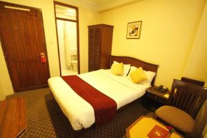 a hotel room with a bed and a desk and a chair at Hotel Marshyangdi in Kathmandu