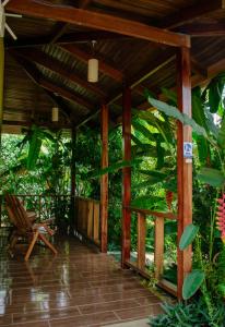a wooden pergola with a chair on a patio at Arenal Descanso in Fortuna