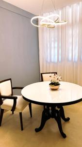 a white table with a vase of flowers on it at Hotel Rancho Verde in Barreiras