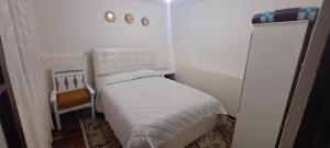 ein kleines Schlafzimmer mit einem kleinen Bett und einem Stuhl in der Unterkunft Apartamento en Miraflores in La Paz