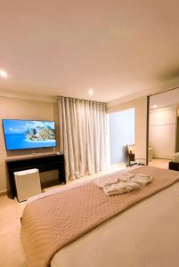 Habitación de hotel con cama y TV de pantalla plana. en Hotel Rancho Verde en Barreiras