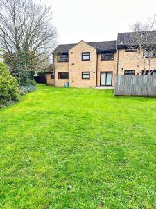 a large yard with a house in the background at 2 Bedroom Flat or Appartment near Heathrow with Garden in Uxbridge