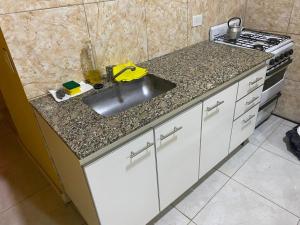 cocina con fregadero y fogones en Departamento entero en Buenos Aires en Merlo