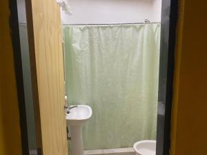 y baño con cortina de ducha y lavamanos. en Departamento entero en Buenos Aires en Merlo