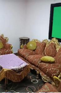 الزيتونة 1 في مكة المكرمة: غرفة معيشة بها أريكة وشاشة خضراء