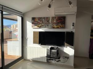 a living room with a flat screen tv on a wall at Appart Duplex Roses Plage in Roses