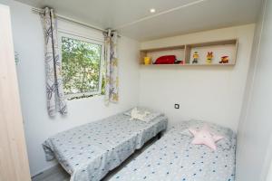 a bedroom with two beds and a window at Camping Le Luberon in Apt