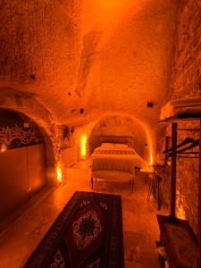 een slaapkamer met een bed in een stenen kamer bij Euphoria Cave House in Nar