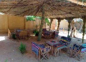 un gruppo di tavoli e sedie sotto un grande ombrellone di سيوة تورز للسياحة العلاجية a Siwa