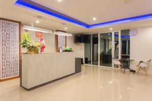 a lobby with a reception counter and a table and chairs at Krabi Inn & Omm in Krabi