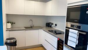 a white kitchen with a sink and a microwave at 310 Arden Gate in Birmingham