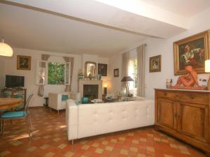 uma sala de estar com um sofá branco e uma mesa em La petite maison de la ferme rose em Moustiers-Sainte-Marie