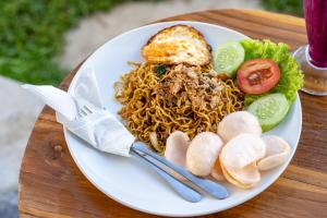 a plate of food with noodles and vegetables on a table at Mountain Peak Kintamani in Kintamani