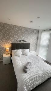 a bedroom with a white bed with a sign on the wall at 310 Arden Gate in Birmingham