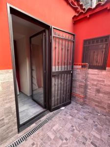 uma porta de entrada para um edifício com uma parede vermelha em Mary House Apartments em Catânia