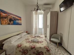 sypialnia z łóżkiem, krzesłem i oknem w obiekcie Casa Aurora w mieście Polignano a Mare