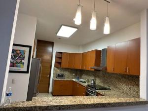 a kitchen with wooden cabinets and stainless steel appliances at Casa hermosa y acogedora en condominio privado in Puerto Vallarta