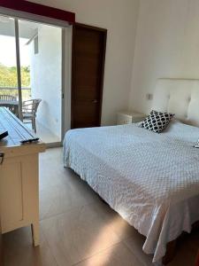1 dormitorio con cama, escritorio y ventana en Casa hermosa y acogedora en condominio privado, en Puerto Vallarta