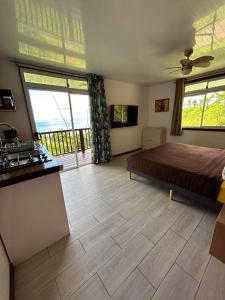 ein Schlafzimmer mit einem Bett und eine Küche mit Fenstern in der Unterkunft Bienvenue au Mati House in Fitii