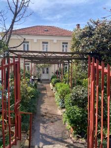 a garden with a red gate in front of a house at Apartment Dora 1 , on the beach in Tivat