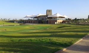 a golf course with a large building in the background at Luxueux appartement Golf City Rez-de-Jardin et Piscine in Marrakesh