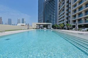 a large swimming pool in a city with buildings at Burj Royale - Burj Khalifa View - 4m Walk to Dubai Mall in Dubai