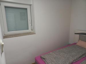 een kleine slaapkamer met een raam en een bed bij KIM in Sarajevo