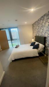 1 dormitorio con 1 cama grande y pared de piedra en 310 Arden Gate, en Birmingham