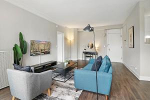 sala de estar con sofá azul y sillas en Enchanting 1BR Urban Retreat in Hyde Park - Windermere 401, en Chicago
