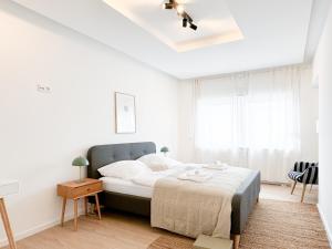 a white bedroom with a bed and a ceiling fan at Lifestyle Penthouse Apartment in Ludwigshafen am Rhein