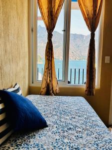 a bedroom with a bed and a large window at Nicolas House #2 with Lake Atitlán View in San Pedro La Laguna