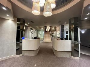een lobby met 2 receptiebalies en een trap bij Hotel Beach Palace in Blankenberge