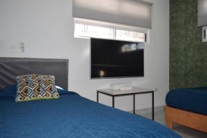 a bedroom with a blue bed and a flat screen tv at Obreros 937, La Alianza Mty in Monterrey