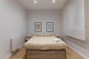 a bedroom with a bed in a white room at Gran apto a 5 min de casco viejo. Familias, grupos in Bilbao