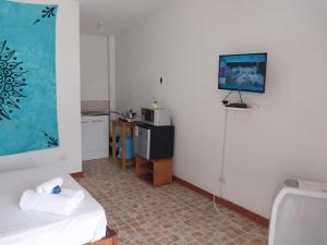 Habitación con cama y TV en la pared. en Casuarinas del Mar Hospedaje Habitacion Cerro 1, en Canoas de Punta Sal