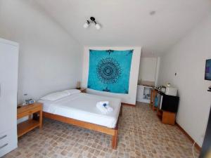 um quarto com uma cama com uma fotografia azul na parede em Casuarinas del Mar Hospedaje Habitacion Cerro 1 em Canoas de Punta Sal