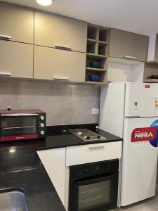 a kitchen with a microwave and a stove and a refrigerator at Yerba Buena House in Yerba Buena