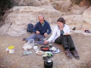 a man and a woman sitting on the ground with food at Dana local life Eco Lodge in Dana