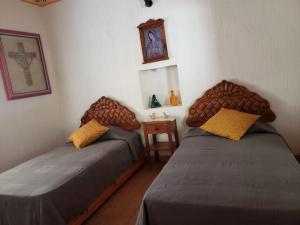 a room with two beds and a table with a mirror at Peña de Bernal Rancho La Trinidad in Cerrito