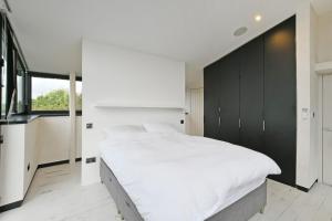ein Schlafzimmer mit einem großen weißen Bett und einem großen Fenster in der Unterkunft West View 3 Bedroom Villa With Hot Tub in Heeley