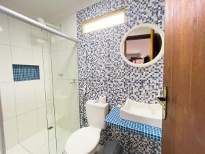 a bathroom with a toilet and a sink and a mirror at Pousada Lua Cheia in Japaratinga