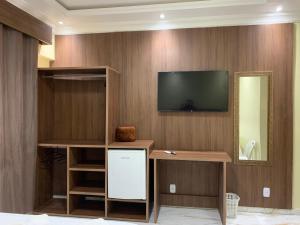 a living room with a television on a wall at Hotel Campos in Itaituba