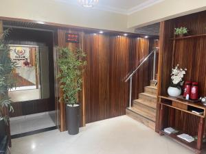 un vestíbulo con paredes de madera y escaleras con plantas en Hotel Campos en Itaituba